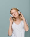 Closeup portrait of young woman closed eyes listening music via headphones on color neutral gray tone Royalty Free Stock Photo