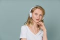 Closeup portrait of young woman closed eyes listening music via headphones on color neutral gray tone Royalty Free Stock Photo