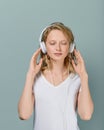 Closeup portrait of young woman closed eyes listening music via headphones on gray tone, vertical Royalty Free Stock Photo