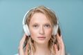 Closeup portrait of young woman closed eyes listening music via headphones on color neutral tone Royalty Free Stock Photo