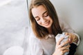 Closeup portrait of a young woman drinking coffee in the morning.