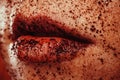 Closeup portrait of a young woman with ground coffee on the lips and face