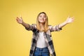 Closeup portrait, young woman motioning with arms to come and give her a bear hug, isolated on yellow background.