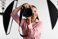 Closeup portrait of young woman photographer taking photo, lady working at studio, using professional dslr camera Royalty Free Stock Photo