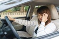 Closeup portrait of young woman touching her temple feels headache in her car after driving car for long time Royalty Free Stock Photo