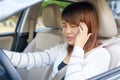 Closeup portrait of young woman touching her temple feels headache in her car after driving car for long time. Royalty Free Stock Photo