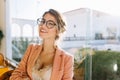 Closeup portrait of young woman wearing stylish glasses, smart lady in elegent pink jacket with beige blouse, cute Royalty Free Stock Photo