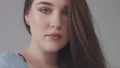 Closeup portrait of young wooman posing to a camera with blowed out hair