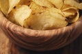 Closeup potato chips with herbs in wood bowl on rustic table Royalty Free Stock Photo