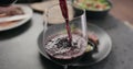 closeup pour red wine in wineglass with steak on background Royalty Free Stock Photo