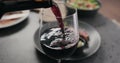 closeup pour red wine in wineglass with steak on background Royalty Free Stock Photo