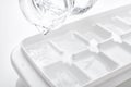 Closeup pouring fresh drink water from a jug into ice cube tray Royalty Free Stock Photo