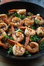 Closeup of prawns shrimps roasted on pan with herbs on rustic wooden kitchen table Royalty Free Stock Photo