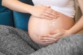 Pregnant woman applying cream on her belly Royalty Free Stock Photo