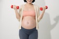 Closeup of pregnant woman doing exercises with dumbbells in the room Royalty Free Stock Photo