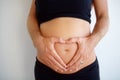 Closeup, pregnant and woman with heart hands, stomach and health with childbirth, support or wellness. Zoom, pregnancy Royalty Free Stock Photo