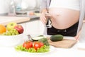 Closeup of pregnant woman holding glass of water on kitchen Royalty Free Stock Photo