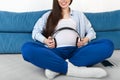Closeup pregnant woman holding headphones on belly