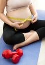 Closeup of pregnant woman measuring belly with tape Royalty Free Stock Photo