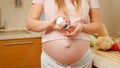 CLoseup of pregnant woman pouring vitamin pills on hand from plastic bottle container. Concept of healthy lifestyle Royalty Free Stock Photo