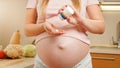 CLoseup of pregnant woman pouring vitamin pills on hand from plastic bottle container. Concept of healthy lifestyle Royalty Free Stock Photo