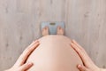 Pregnant woman standing on scales Royalty Free Stock Photo