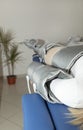 Closeup pressure therapy procedure. Woman lying in massaging suit in hospital, treatment
