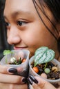 Pretty Asian Teen Girl Holding Baby Tropical Plants