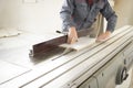 Closeup process of carpenter worker with circular saw machine at wood beam cross cutting during furniture manufacture Royalty Free Stock Photo