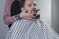 Closeup process of haircut and beard care. A professional master prepares a clients beard for cutting and shaving a beard. Makes