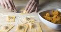 Closeup process making ravioli vegan homemade pasta. Housewife cook closes with a fork `tortelli di zucca`, traditional italian