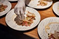 Closeup of professional chef plating dish.