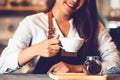 Closeup of professional female barista hand making and holding white cup of coffee. Happy young woman at counter bar in restaurant Royalty Free Stock Photo