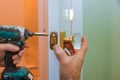 Closeup of a professional locksmith installing or new lock on a house door with screwdriver