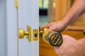 Closeup of a professional locksmith installing or new lock on a house door with screwdriver Royalty Free Stock Photo