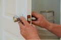 Closeup of a professional locksmith installing or repairing a new deadbolt lock Royalty Free Stock Photo