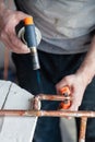 Closeup professional master plumber hands soldering copper pipes gas burner. Concept installation, plumbing replacement, solder Royalty Free Stock Photo