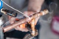 Closeup professional master plumber holding flux paste for soldering and brazing seams of copper pipe gas burner. Concept Royalty Free Stock Photo