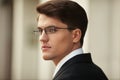 Closeup profile portrait of a handsome businessman in eyeglasses and black suit and white tie and shirt. Royalty Free Stock Photo