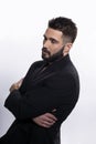 Closeup profile portrait of a handsome, strong, brutal bearded man posing in black suit, isolated white background. Royalty Free Stock Photo