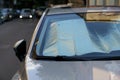 Protective reflective surface under windshield of car on hot day, heated by sun's rays inside car