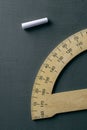 Protractor and piece of chalk on a chalkboard Royalty Free Stock Photo