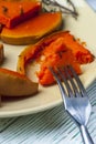 Closeup of pumpkin piece with fork on yellow plate Royalty Free Stock Photo