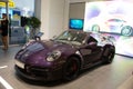 Closeup of a purple Porsche parked in a modern showroom under the bright light in Armenia