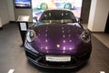 Closeup of a purpule Porsche parked in a modern showroom under the bright light in Armenia