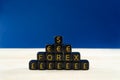 Closeup of a pyramid of black cubes with forex and dollar, euro and pound sterling signs on them.