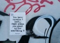 Closeup of a quote on a wall with graffiti art