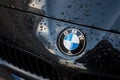 closeup of rain drops on bmw logo in front car parked in the street Royalty Free Stock Photo