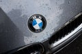 Closeup of rain drops on the logo of grey Bmw car parked in the street Royalty Free Stock Photo