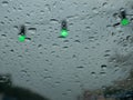 Driving in the rain on a grey nasty day on green traffic light Royalty Free Stock Photo